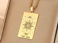 a close up of a gold necklace with an engraving on it