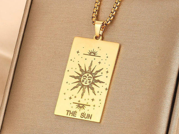 a close up of a gold necklace with an engraving on it
